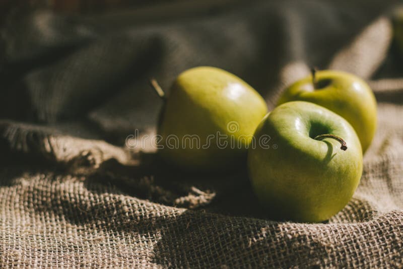 Trois pommes vertes mûres sur le tissu rustique photos libres de droits Trois pommes vertes mûres sur le tissu rustique photos libres de droits