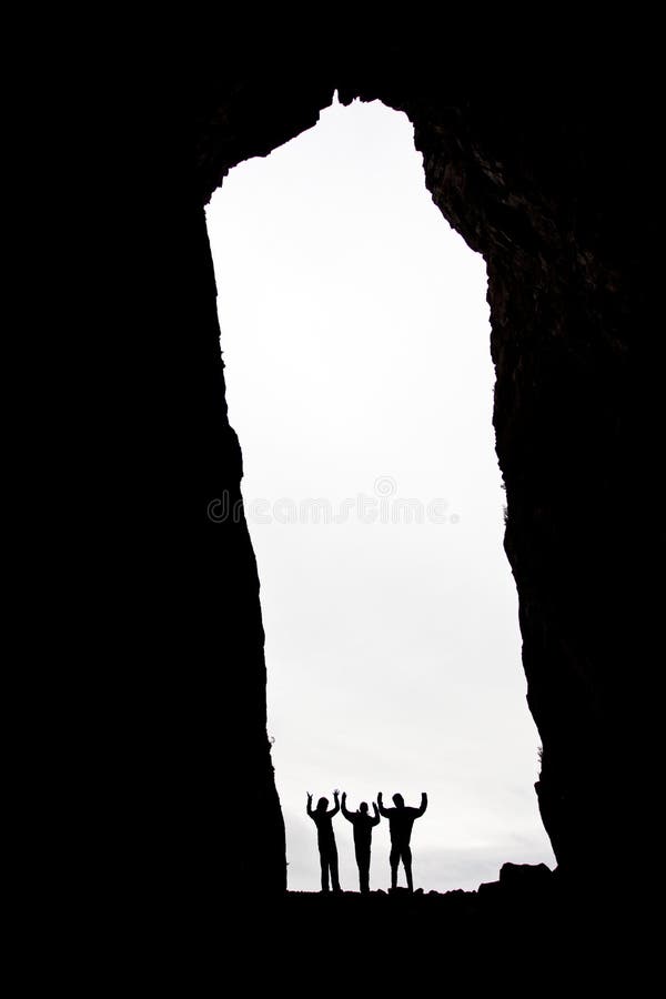 Three silhouettes in a cave opening. Three silhouettes in a cave opening