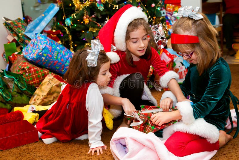 Trois soeurs ouvrant des cadeaux de Noël photo libre de droits Trois soeurs ouvrant des cadeaux de Noël photo libre de droits