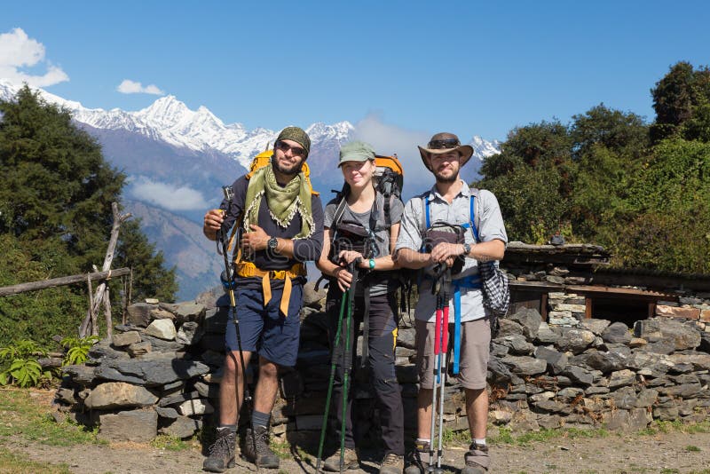 Three backpackers tourists group selfie posing in front snow mountains peaks ridge. Gosaikunda trekking route, Langtang park mountains region, Nepal. Three backpackers tourists group selfie posing in front snow mountains peaks ridge. Gosaikunda trekking route, Langtang park mountains region, Nepal.