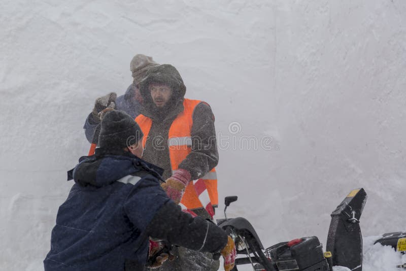 Trois travailleurs dans une tempête de neige pendant le déblaiement de neige images libres de droits Trois travailleurs dans une tempête de neige pendant le déblaiement de neige images libres de droits