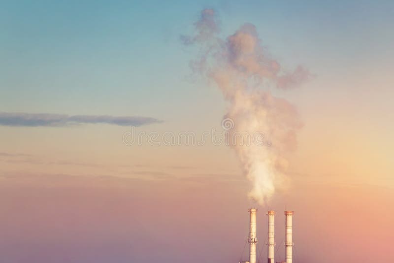 Trois tuyaux de cheminée d'évacuation des fumées faisant des nuages de la fumée blanche avec le fond dramatique de ciel de couche photo stock Trois tuyaux de cheminée d'évacuation des fumées faisant des nuages de la fumée blanche avec le fond dramatique de ciel de couche photo stock
