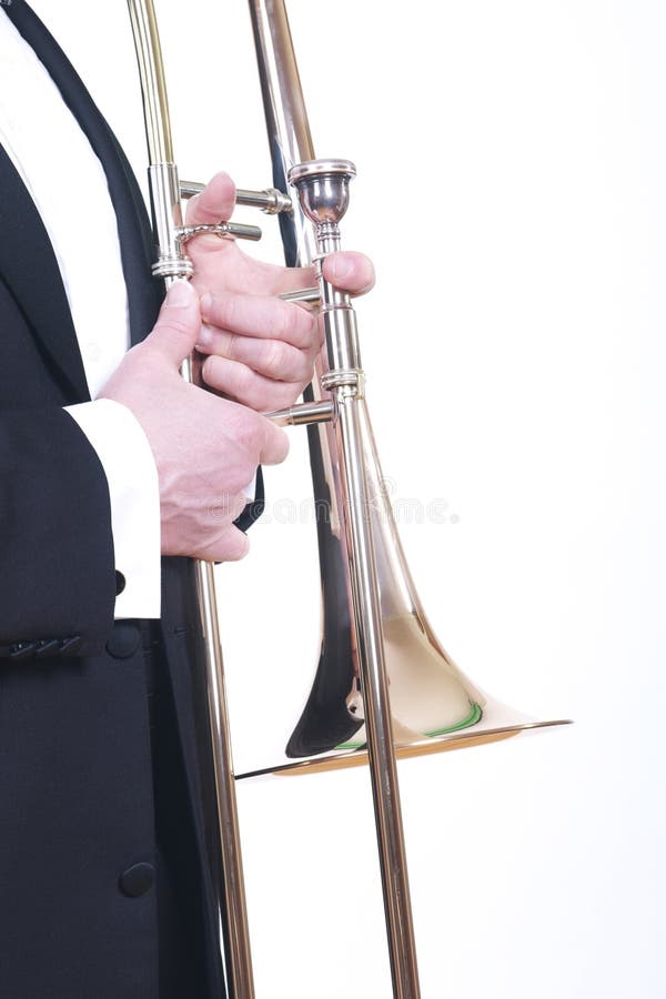 A caucasian male wearing a tuxedo holds a trombone. Isolated on white. A caucasian male wearing a tuxedo holds a trombone. Isolated on white.