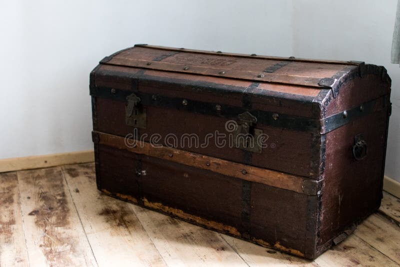 dark wood trunk in a country house. antique treasure chest with metal hinges to store clothes and materials. dark wood trunk in a country house. antique treasure chest with metal hinges to store clothes and materials