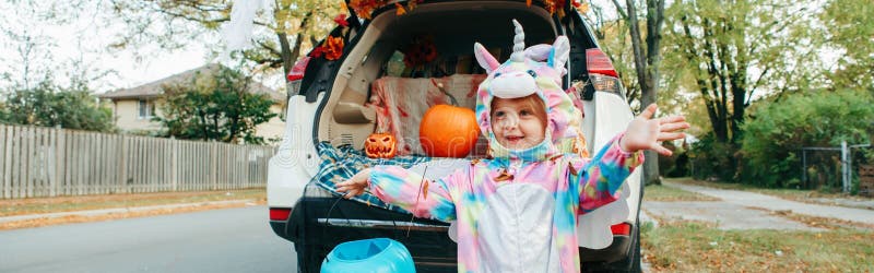 Tronco o tronco Felice bambino in costume di unicorn che festeggia Halloween nel bagagliaio dell'auto Bambino carino che si prepa