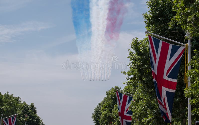 Trooping of the Colour parade, above Buckingham Palace. Nine Red Arrow planes fly in formation. Union jack flags in foreground royalty free stock image Trooping of the Colour parade, above Buckingham Palace. Nine Red Arrow planes fly in formation. Union jack flags in foreground royalty free stock image