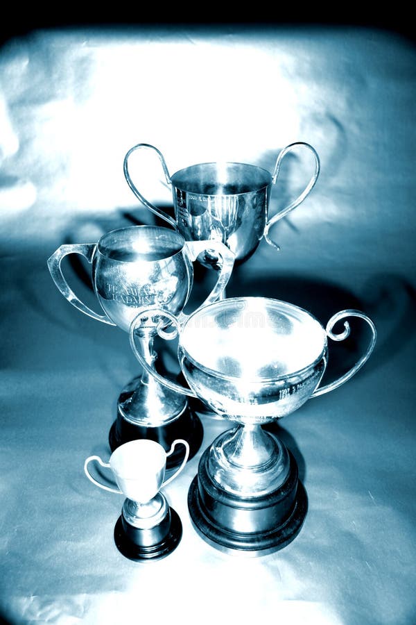 Trophies. In varying sizes with handles at side, blue and silver tones royalty free stock images