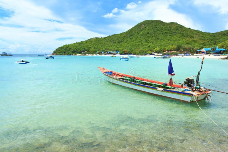 Tradition wood boat at beautiful rock beach sea island with mountain and blue sky background landscape