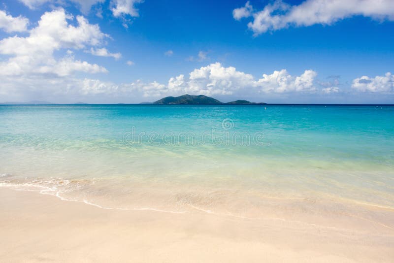 Scenic view of idyllic tropical beach with blue sea, sky and cloudscape background, Cane Garden Bay, Tortola island, British Virgin islands. Scenic view of idyllic tropical beach with blue sea, sky and cloudscape background, Cane Garden Bay, Tortola island, British Virgin islands.