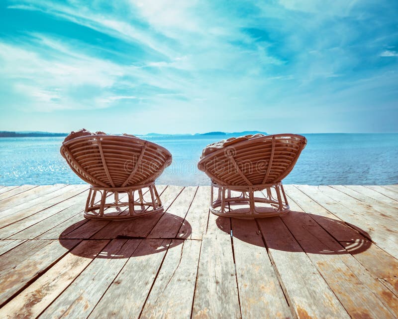 Tropical beach with chairs on wooden terrace