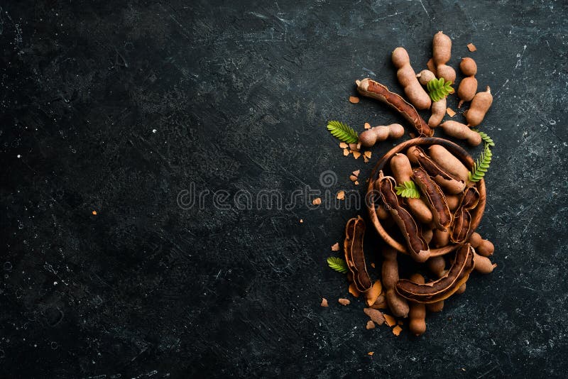 Tropical fruits. ripe tamarind. On a stone background. stock photography