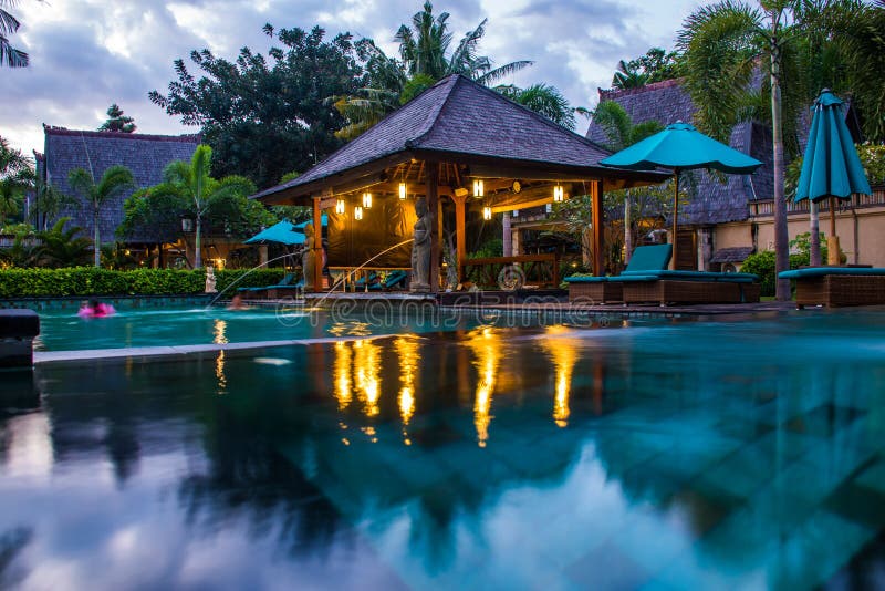 Tropical hotel with swimming pool at night with reflections and palms, Gili Trawangan, Lombok, Indonesia