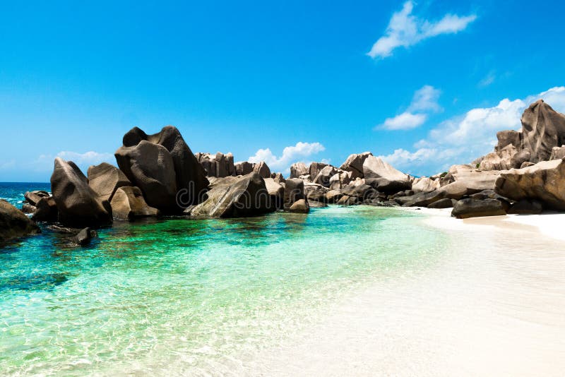Tropical natural beach with green lagoon, white sand and big rocks, Anse Marron beach in La Digue, Seychelles