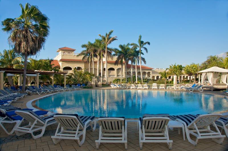 Tropical resort chairs around swimming pool. Tropical resort chairs around swimming pool