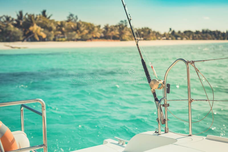 Tropical sea and island view from boat and fishing in shallow tropical sea. Tropical fishing rod view from a boat. Exotic location, shallow sea, lagoon with stock image Tropical sea and island view from boat and fishing in shallow tropical sea. Tropical fishing rod view from a boat. Exotic location, shallow sea, lagoon with stock image