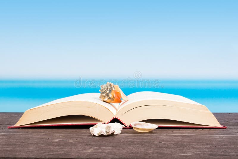 Tropical sea seen from the boat. Book on table. Reading and relaxing on vacation