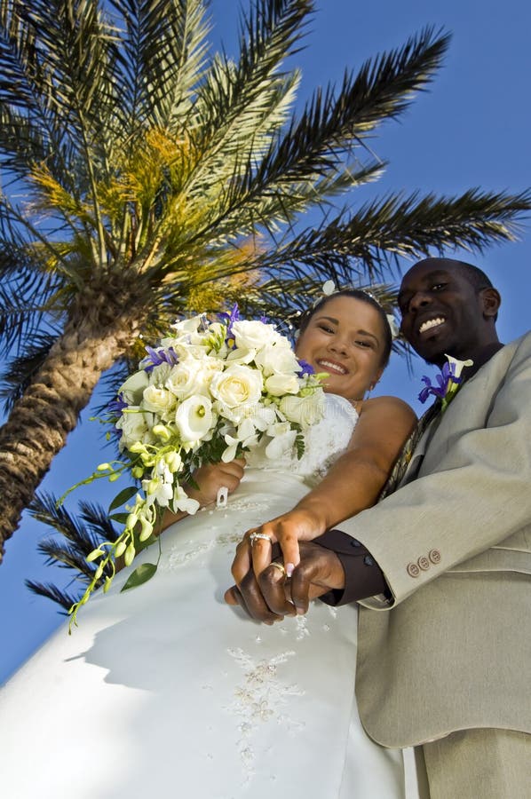 Tropical wedding couple holding hands