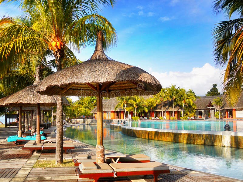 Luxury Holiday Resort -a tropical garden with pools, loungers and parasols near beach. Mauritius island. Indian Ocean. Luxury Holiday Resort -a tropical garden with pools, loungers and parasols near beach. Mauritius island. Indian Ocean.