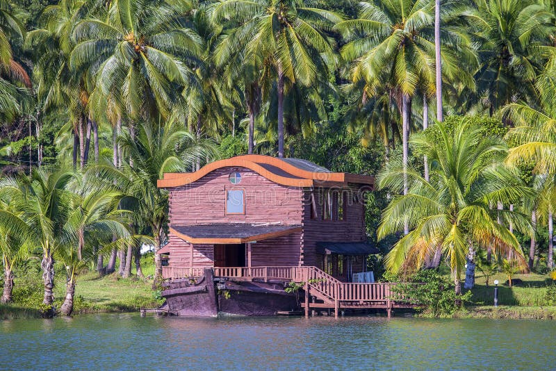 Tropisch huis in de vorm van een schip naast het overzees in de wildernis met groene palmen De toevlucht van het luxestrand op ee royalty-vrije stock foto Tropisch huis in de vorm van een schip naast het overzees in de wildernis met groene palmen De toevlucht van het luxestrand op ee royalty-vrije stock foto