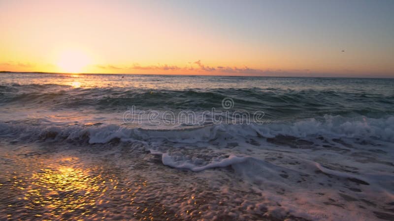 Tropischer Sonnenaufgang über dem Strand Meereswellen den Sand waschend