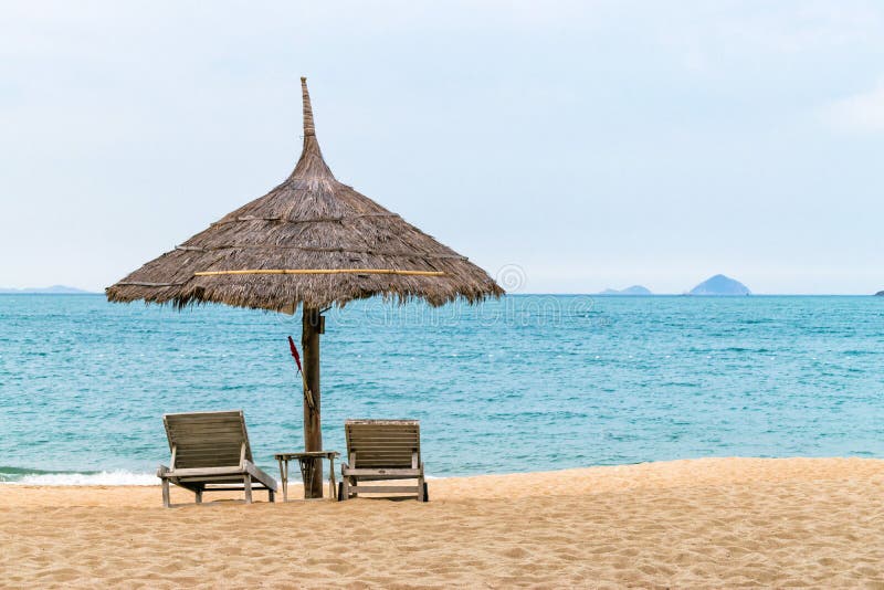 Tropischer Strand mit H?tte und St?hle nahe Ozean lizenzfreies stockfoto Tropischer Strand mit H?tte und St?hle nahe Ozean lizenzfreies stockfoto