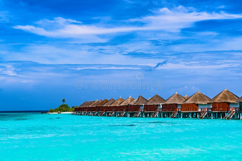 Tropischer Strand und Overwater-Bungalow lizenzfreie stockfotografie