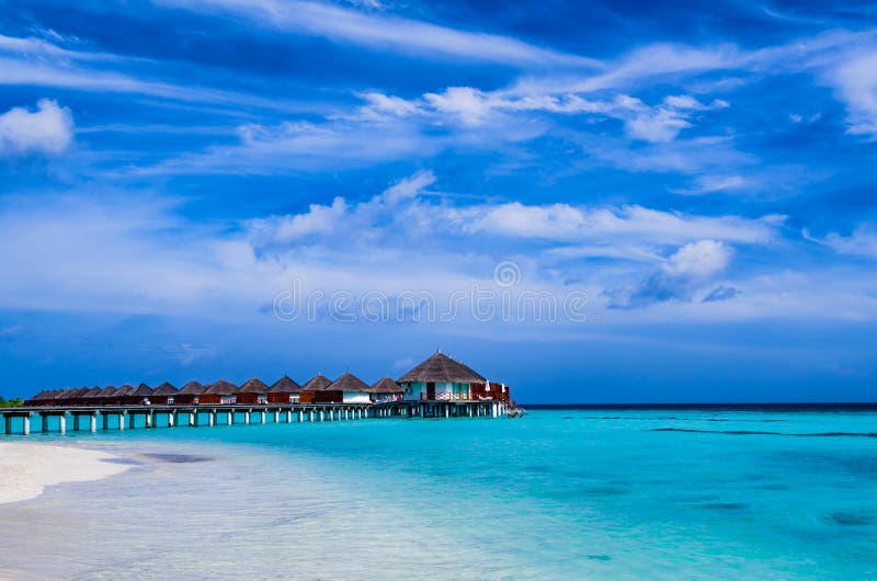 Tropischer Strand und Overwater-Bungalow lizenzfreie stockfotografie