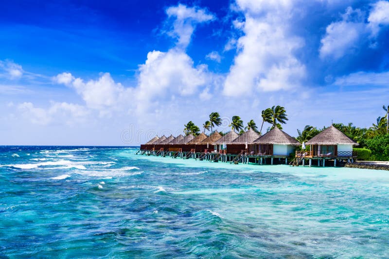 Tropischer Strand und Overwater-Bungalow stockfotografie