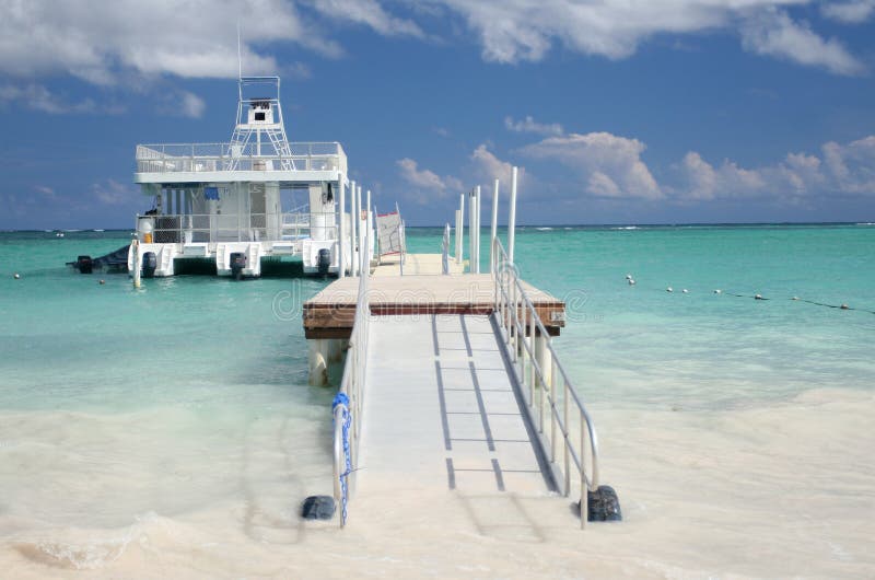 Beautiful Caribbean tropical beach with white sand and ferry boat in green ocean, suitable background for a variety of designs. Beautiful Caribbean tropical beach with white sand and ferry boat in green ocean, suitable background for a variety of designs