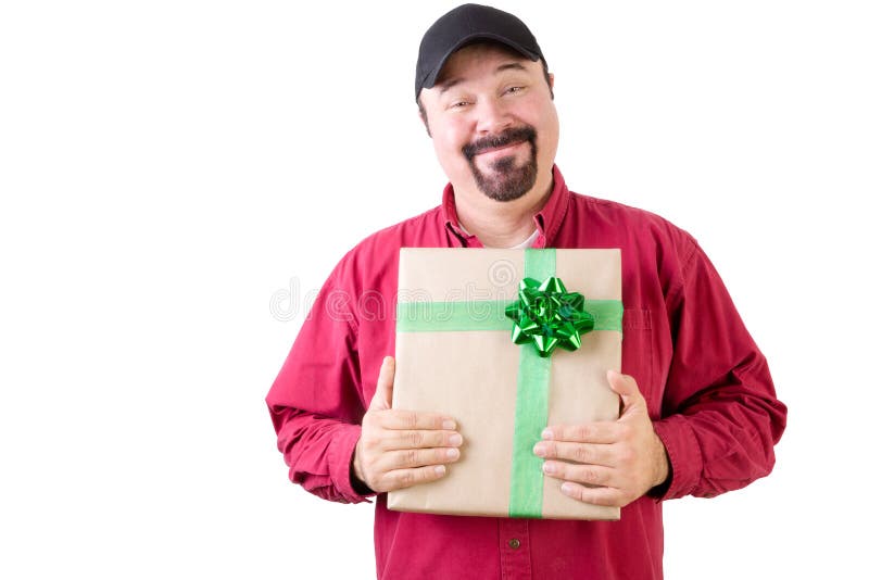 Proud single man in hat and red long sleeve shirt holding a Christmas gift wrapped in gold paper and green ribbon. Proud single man in hat and red long sleeve shirt holding a Christmas gift wrapped in gold paper and green ribbon