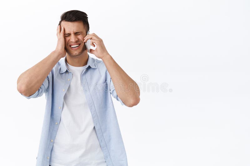 Troubled and upset handsome man forgot about appointment, grimacing frustrated touch head, having phone conversation with person, remembered important task during mobile call.