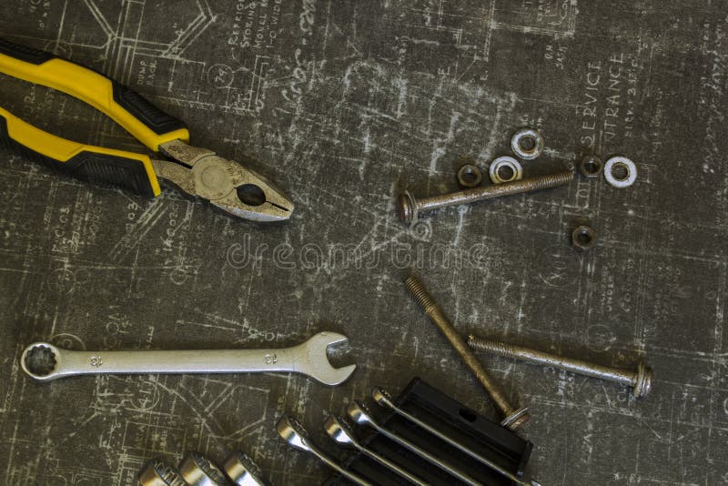 Trousse d'outils des pinces, des cl?s, des boulons et des ?crous sur la surface grise abstraite image libre de droits Trousse d'outils des pinces, des cl?s, des boulons et des ?crous sur la surface grise abstraite image libre de droits