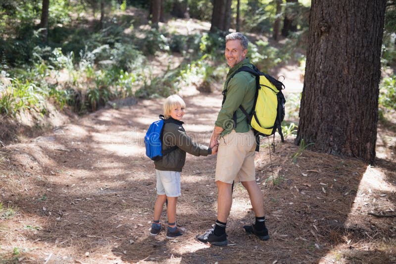 Trouxa levando de sorriso do pai e do filho ao caminhar na floresta