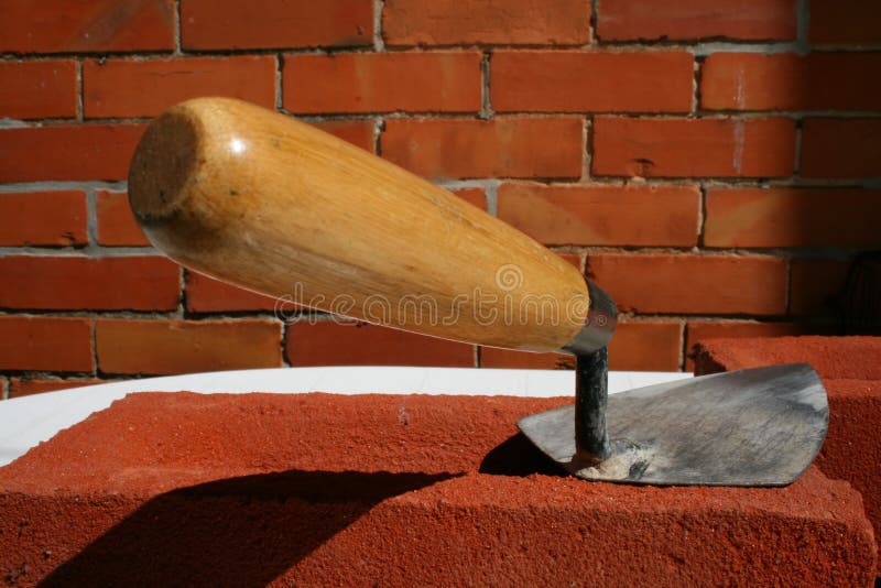 Constructores muestra cuchara de albanil sobre el casa ladrillo.