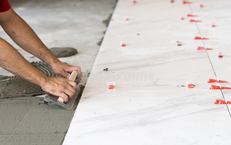 troweling mortar onto concrete floor preparation laying white tile ceramic tiles 228010674