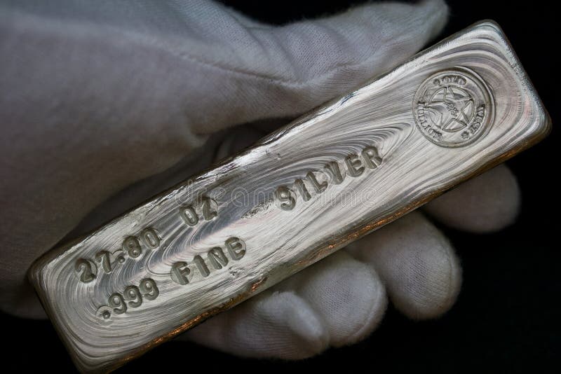27.80 troy ounce silver bullion bar held in hand. This is a hand-poured and stamped ingot. 27.80 troy ounce silver bullion bar held in hand. This is a hand-poured and stamped ingot.