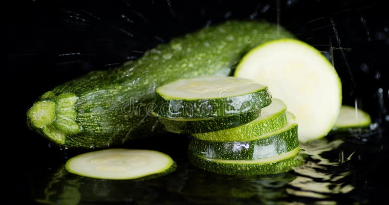 Trozos enteros y redondos de zucchini con gotas de agua. almacen de metraje de vídeo