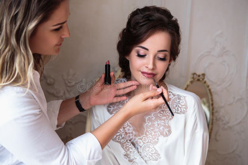 Truccatore che prepara bella sposa prima delle nozze in una mattina immagini stock libere da diritti Truccatore che prepara bella sposa prima delle nozze in una mattina immagini stock libere da diritti
