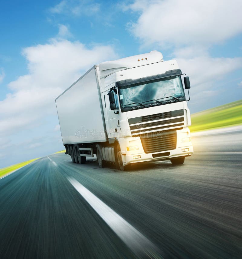 Bianco camion su strada asfaltata sotto il cielo azzurro con le nuvole.