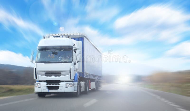 A truck is running on a national road, with blurred background, blue sky and white clouds stock photography
