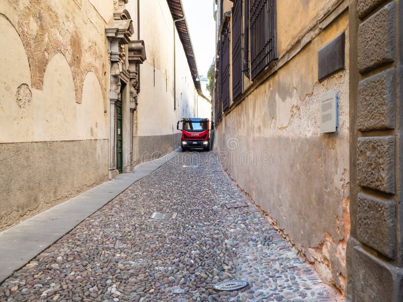 Truck drive on narrow medieval street in Bergamo stock photo Truck drive on narrow medieval street in Bergamo stock photo