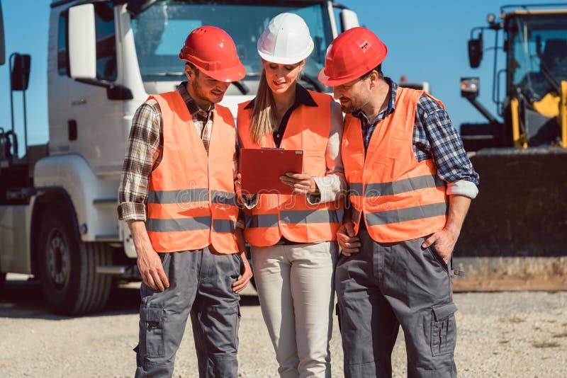 Truck drivers and dispatcher in front of lorries in freight forwarding company royalty free stock photo