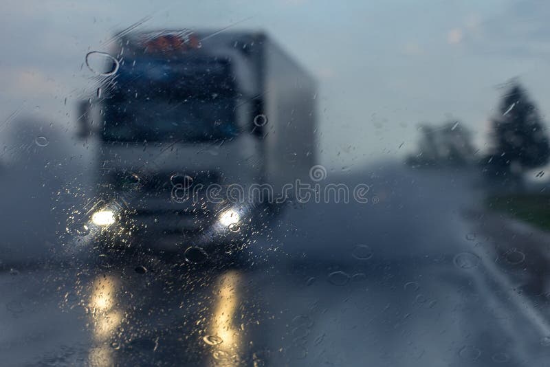 Camión en la lluvia, a través de auto.