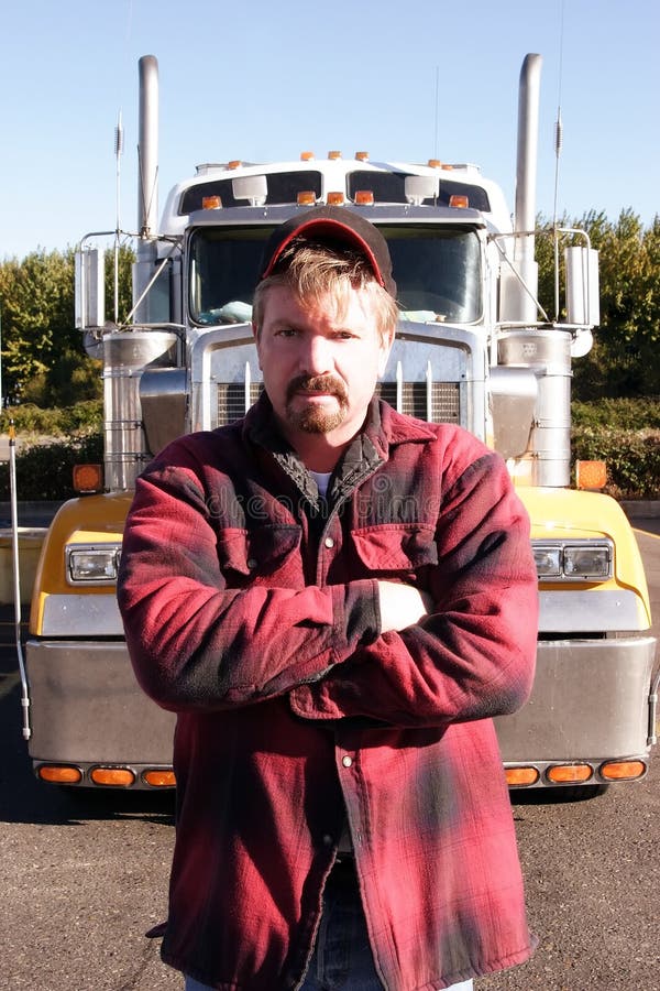 Una fotografia di scorta di un lungo raggio di camion e di un autista di camion a una fermata di camion.