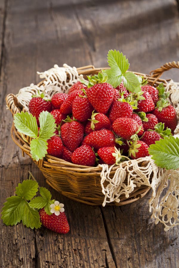 Strawberries in basket on rustic wooden background. Strawberries in basket on rustic wooden background