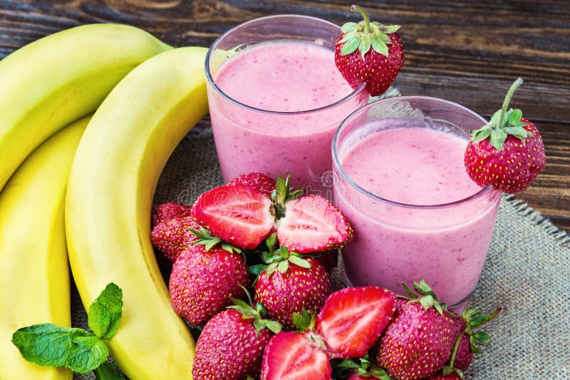 Truskawkowy i bananowy smoothie w szkle świeże truskawki obrazy stock Truskawkowy i bananowy smoothie w szkle świeże truskawki obrazy stock