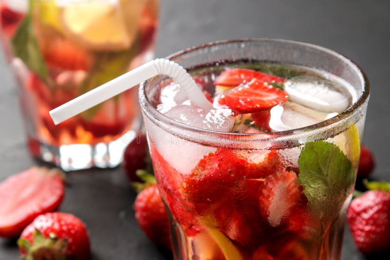 Truskawkowy Mojito Zimny lata mojito koktajl z truskawkami, mennicą, cytryną i lodem w szkle na czarnym stole, Zako?czenie obraz stock Truskawkowy Mojito Zimny lata mojito koktajl z truskawkami, mennicą, cytryną i lodem w szkle na czarnym stole, Zako?czenie obraz stock
