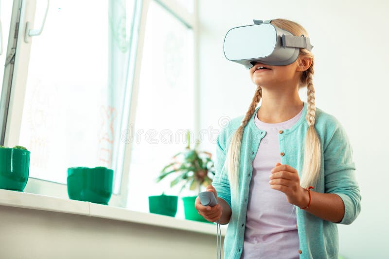 Impressed schoolgirl playing virtual games at school. royalty free stock photo