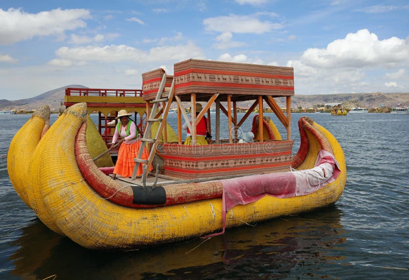 Trzcinowa łódź z rodzimymi ludźmi przy Uros Spławowymi wyspami w Jeziornym Titicaca Peru fotografia stock
