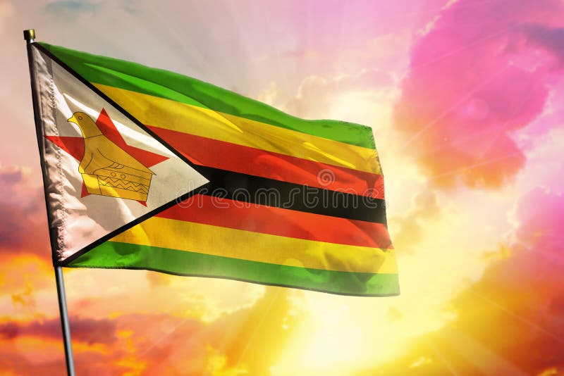 Trzepotająca flaga zimbabwe na pięknym, kolorowym zachodzie słońca lub tle wschód słońca. koncepcja sukcesu fotografia stock